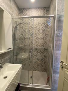 a shower with a glass door next to a sink at 1st line apartment in Kobuleti in K'obulet'i