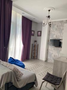 1 dormitorio con 1 cama, ventana y TV en 1st line apartment in Kobuleti, en Kobuleti