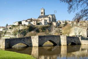 a bridge over a river with a town in the background at Gîte pour professionnels en déplacement - CENTRE VILLE - Parking gratuit in Bellac