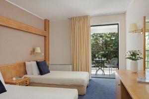 a hotel room with two beds and a balcony at Sun Beach Hotel in Agia Triada