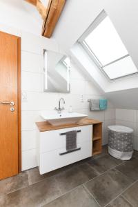 a bathroom with a sink and a skylight at Ferienwohnung im Haus Windrose in Wittmund