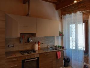 une cuisine avec évier et cuisinière ainsi qu'une fenêtre dans l'établissement Casa Clery, stile toscano, vicino a firenze, à Montelupo Fiorentino