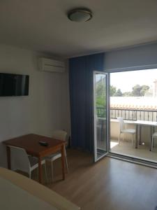 a living room with a table and a sliding glass door at Apartment Nada in Tučepi