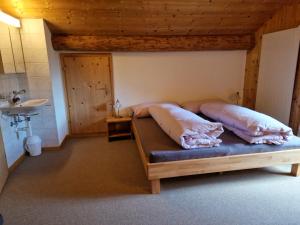 a bedroom with two beds and a sink at 2 Zimmer Ferienwohnung Davos-Glaris in Glaris