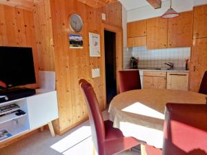 - une cuisine et une salle à manger avec une table et des chaises dans l'établissement 2 Zimmer Ferienwohnung Davos-Glaris, à Glaris