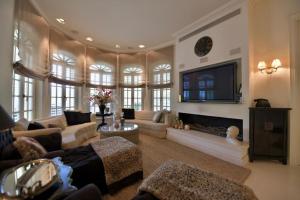 uma sala de estar com um sofá e uma televisão em The Dudai Titanic Mansion em Savyon