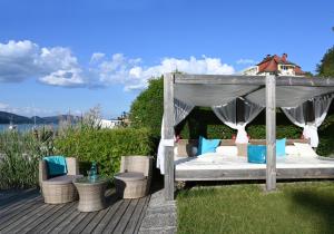 a canopy bed and chairs on a deck at Ferienparadies Truppe in Velden am Wörthersee