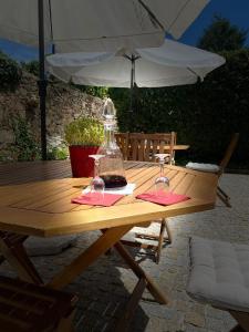 een houten tafel met twee wijnglazen erop bij Casa de Carrapatelo in Mesão Frio