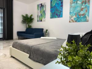 a bedroom with a bed and a blue chair at Eva Del Mar - Sea view - Parcare Privata Inclusa in Mamaia