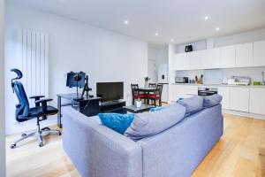 Statera Apartments - City Terraces في لندن: غرفة معيشة مع أريكة ومطبخ