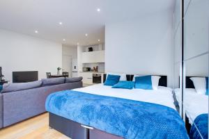 Statera Apartments - City Terraces في لندن: غرفة نوم بسرير كبير وأريكة