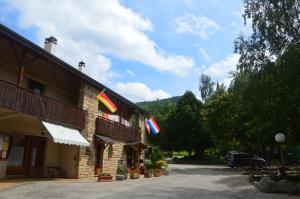 um edifício com bandeiras na lateral em Camping Chon du Tarn em Bédouès