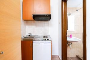 a small kitchen with a sink and a stove at Studios Pinelopi in Skala Potamias +15 photos