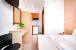 a small room with a bed and a kitchen at Studios Pinelopi in Skala Potamias