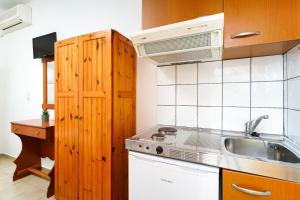 a small kitchen with a sink and a microwave at Studios Pinelopi in Skala Potamias