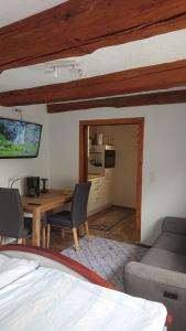 ein Wohnzimmer mit einem Tisch und Stühlen sowie eine Küche in der Unterkunft Kleine gemütliche Ferienwohnung im Fachwerkstil in Wolfsburg