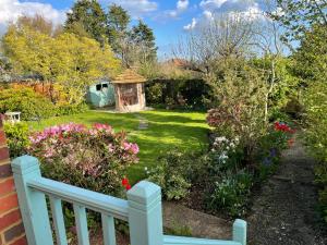 un jardín con una valla blanca y flores en Studio Annie en Findon