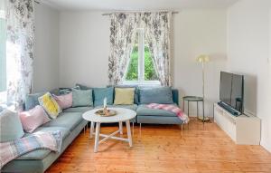 sala de estar con sofá azul y mesa en Nice Home In Edsbruk With Kitchen en Edsbruk