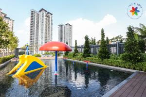 una piscina con scivolo e ombrellone di The Pano @ Jalan Ipoh by Lily and Loft a Kuala Lumpur