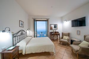 a bedroom with a bed and a table and a chair at Solaria in Amalfi