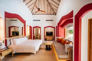 a bedroom with a king sized bed and a couch at Phulay Bay, A Ritz-Carlton Reserve in Tab Kaek Beach