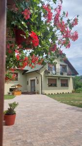 a house with red flowers in front of it at U Gosi Zator in Zator