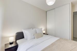 1 dormitorio con 1 cama blanca grande con almohadas blancas en Lumineux 3 pièces Paris / Disney, en Champs-Sur-Marne