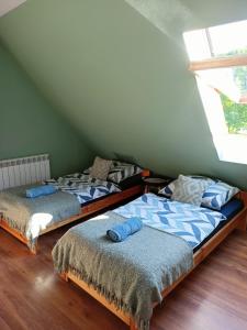 two beds in a room with a attic at Świerkowe Siedlisko pokoje gościnne in Węgorzewo