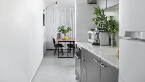 a kitchen with white appliances and a table with chairs at Amazing big studio sea view apartment - By Edom in Eilat