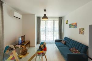 ein Wohnzimmer mit einem blauen Sofa und einem Glastisch in der Unterkunft ComfortMe in Sofia