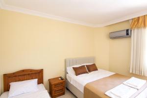 a bedroom with two beds and a air conditioner at Yeşilkaya Hotel in Kayakoy