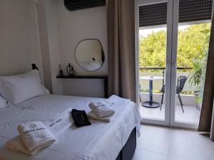 a bedroom with a bed and a mirror and a balcony at Liberty Square in Volos