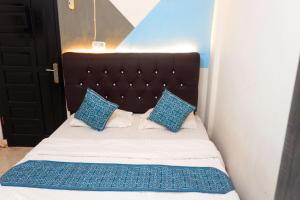 a bed with blue and white pillows on it at Kasmarani Homestay in Palembang
