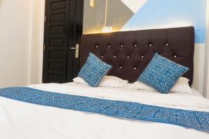 a bed with blue and white pillows on it at Kasmarani Homestay in Palembang
