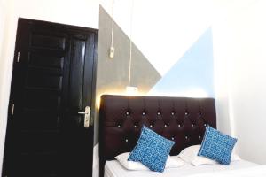 a bedroom with a bed with blue pillows on it at Kasmarani Homestay in Palembang