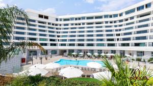 an exterior view of a large building with a pool at דירת סטודיו מרווחת במתחם סי סייד עם חניה פרטית -By Edomlux in Eilat