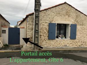 un bâtiment avec des portes bleues et une fenêtre dans l'établissement Clos des Aigrettes, La Cotinière, à La Cotinière