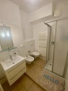 ein Bad mit einem Waschbecken, einem WC und einer Dusche in der Unterkunft Bella Ariston in Meran