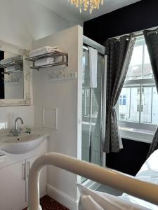 baño con lavabo y ventana en Blue Sky Guest House en Brighton & Hove