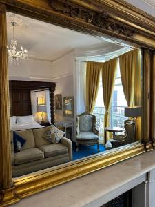 a mirror reflecting a bedroom with a bed and a couch at Blue Sky Guest House in Brighton & Hove