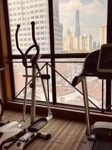 - une salle de sport avec deux vélos d'exercice devant une fenêtre dans l'établissement Magnificent International Hotel, à Shanghai
