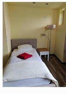 um quarto com uma cama com uma toalha vermelha em Hostel & Hotel Braunlage em Braunlage