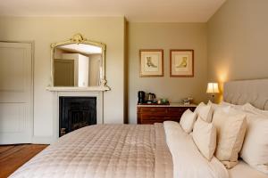 a bedroom with a bed with a mirror and a fireplace at Verandah Cottage B&B 