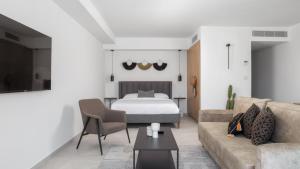 un salon avec un lit et un canapé dans l'établissement סוויטה בסי סייד עם מרפסת - By Edomlux, à Eilat
