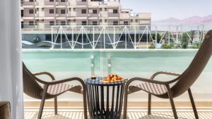 een tafel en stoelen op een balkon met uitzicht bij Big studio with Balcony 100M from the beach - By Edom in Eilat