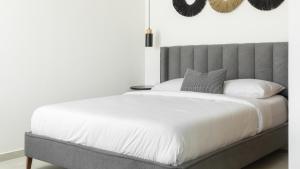 - une chambre avec un lit blanc et une tête de lit gris dans l'établissement סוויטה בסי סייד עם מרפסת - By Edomlux, à Eilat 13 autres photos