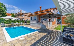 einen Pool mit Sonnenschirm und ein Haus in der Unterkunft Lotus Villas Resort in Pula
