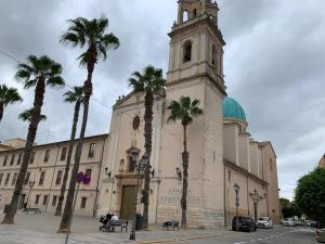 a large building with a clock tower and palm trees at Sueca 1 in Sueca