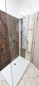 La salle de bains est pourvue d'une douche avec une porte en verre. dans l'établissement Casa Karmèl, à Porto Torres