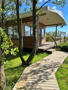 una pequeña casa con una pasarela de madera que conduce a ella en Summer house - Fíflholt, en Hvolsvöllur